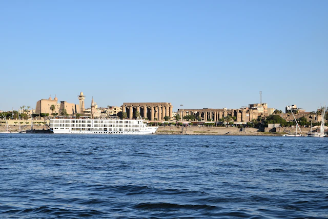 A breathtaking view of Luxor from the Nile River, showcasing the monumental Luxor Temple with its grand columns. In the background, the Mosque of Abu Haggag adds a spiritual touch, blending Islamic heritage with the ancient grandeur of this historic city.