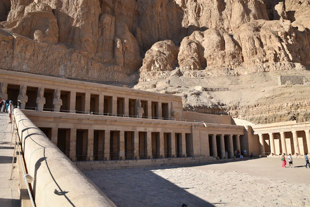 A closer view of the Temple of Hatshepsut in Luxor, where elegant statues and columns reflect the architectural brilliance of ancient Egypt, framed by towering cliffs.