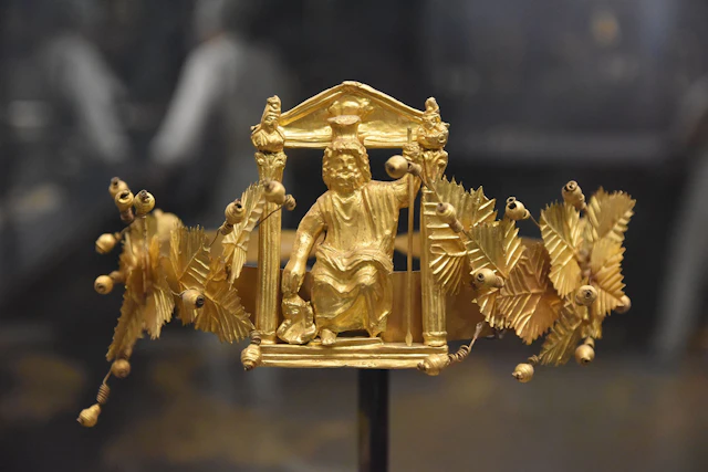 An ancient gold crown from the National Museum in Cairo, adorned with detailed motifs and a central figure, reflecting the artistic mastery of ancient civilizations.