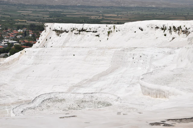 The breathtaking travertine terraces of Pamukkale, Turkey, formed by centuries of mineral deposits from natural hot springs, create a surreal landscape of white cascades.