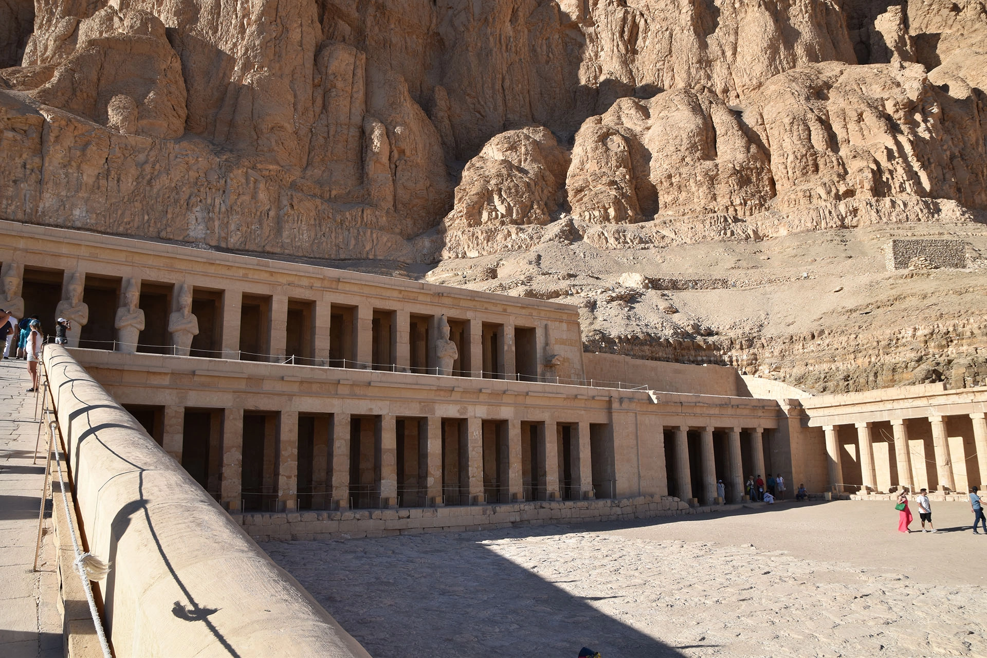A closer view of the Temple of Hatshepsut in Luxor, where elegant statues and columns reflect the architectural brilliance of ancient Egypt, framed by towering cliffs.
