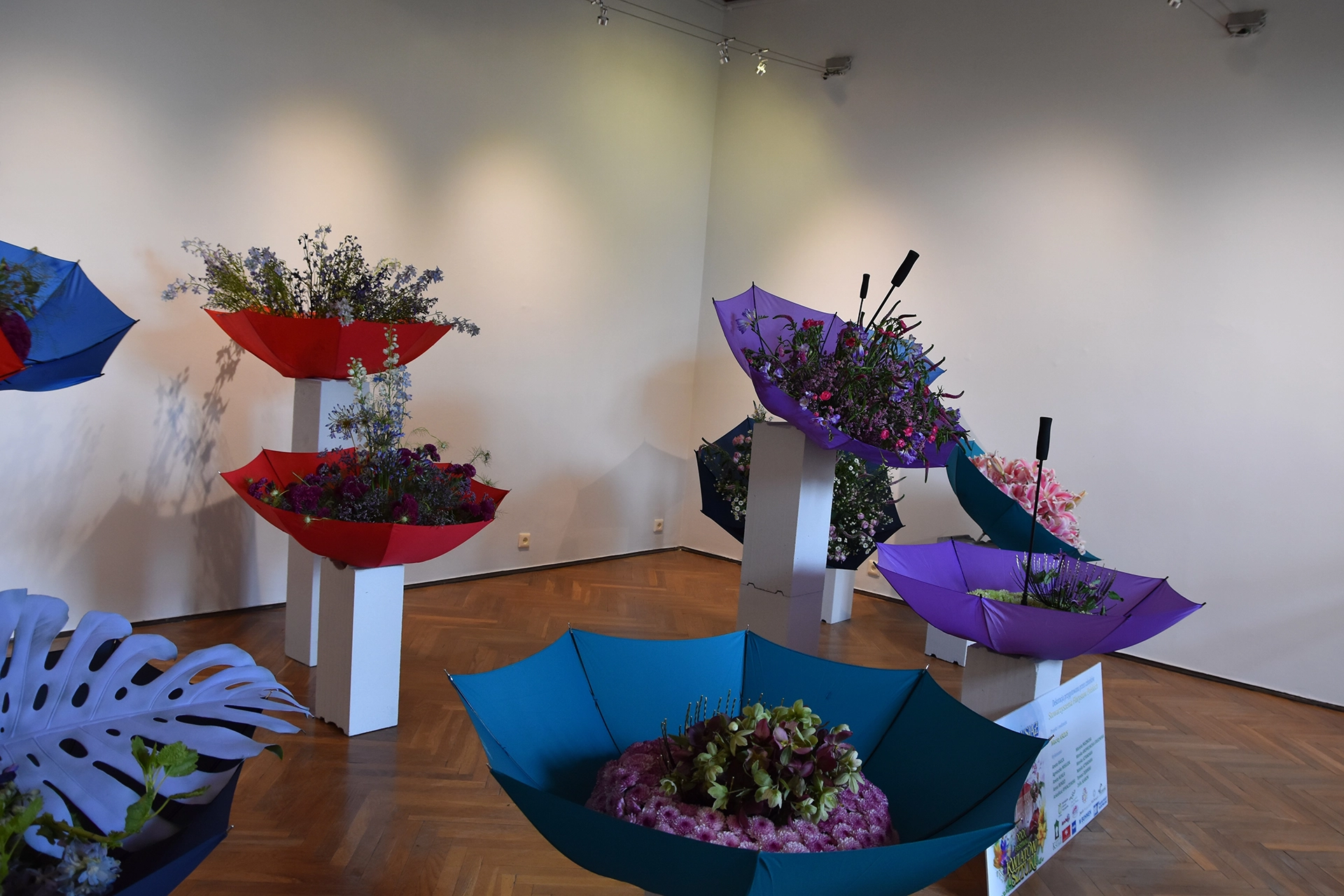 Inside Ksiaz Castle, the floral festival continues with stunning umbrella-themed arrangements featuring orchids, lisianthus, delphiniums, and chrysanthemums, celebrating vibrant colors and creativity.