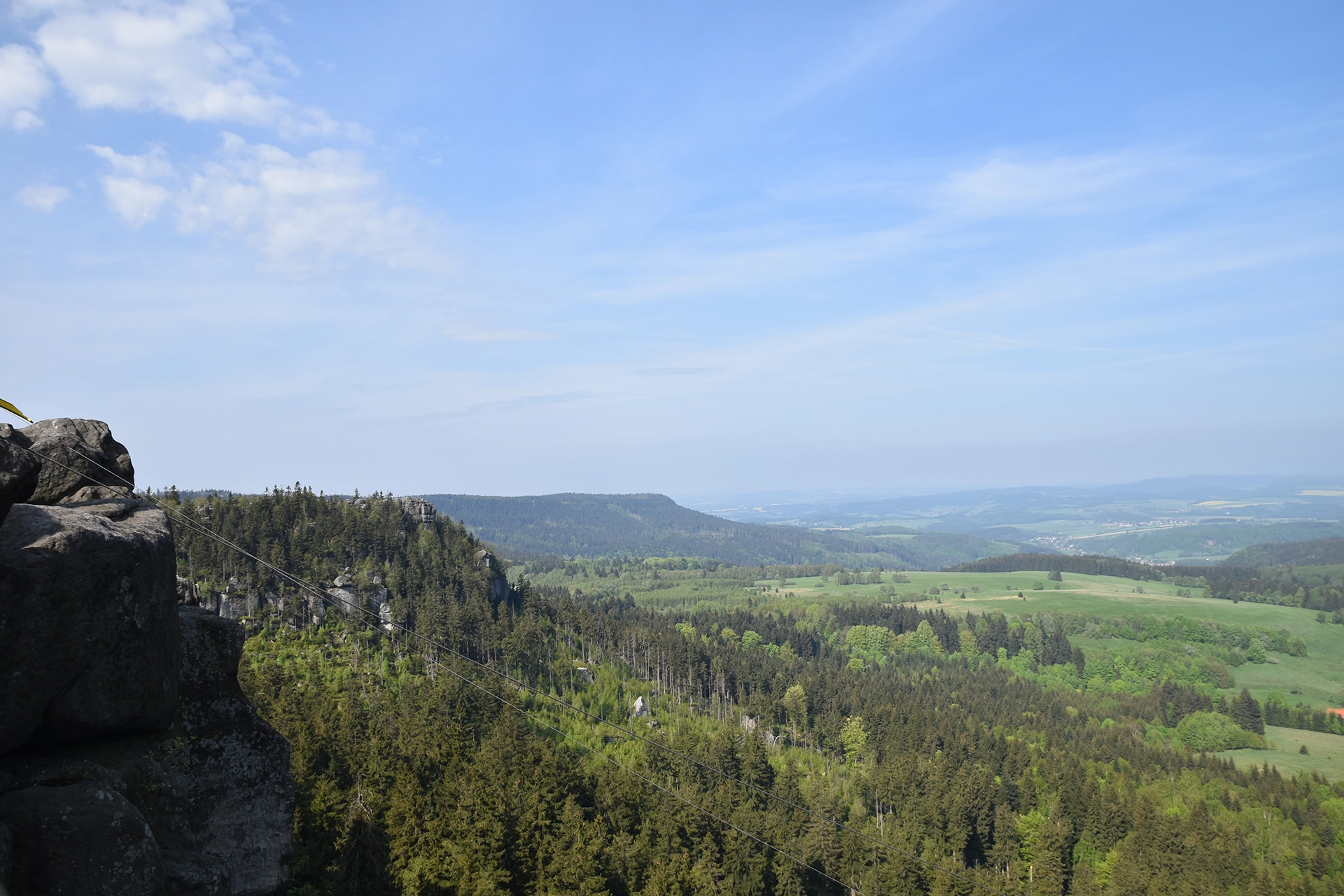 Another perspective from the Table Mountains near Kudowa Zdroj reveals expansive rolling hills, dense forests, and distant fields. This serene landscape emphasizes the area's natural charm and scenic vistas.