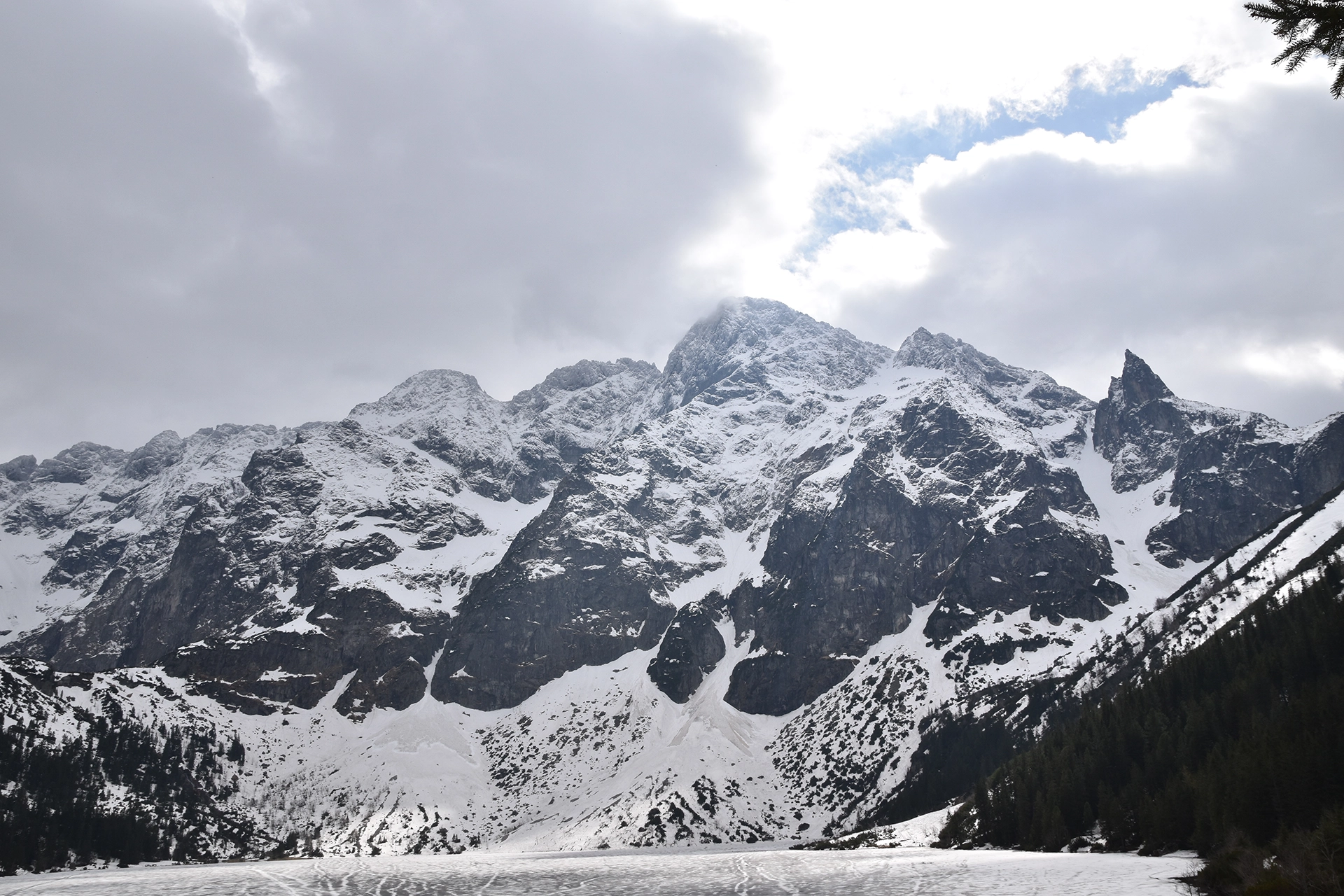 Snow-covered Mieguszowiecki Summits tower above Morskie Oko, creating a dramatic and iconic alpine view in the heart of the Tatra Mountains.